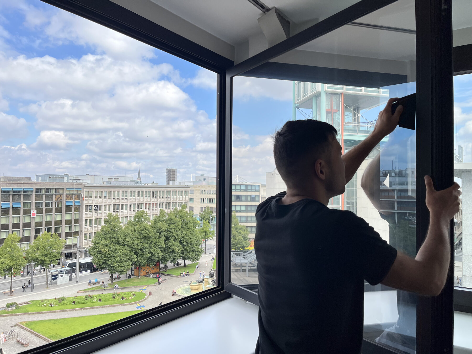 Montage von Sonnenschutzfolie auf Bürofenster mit Blick auf die Mannheimer Innenstadt